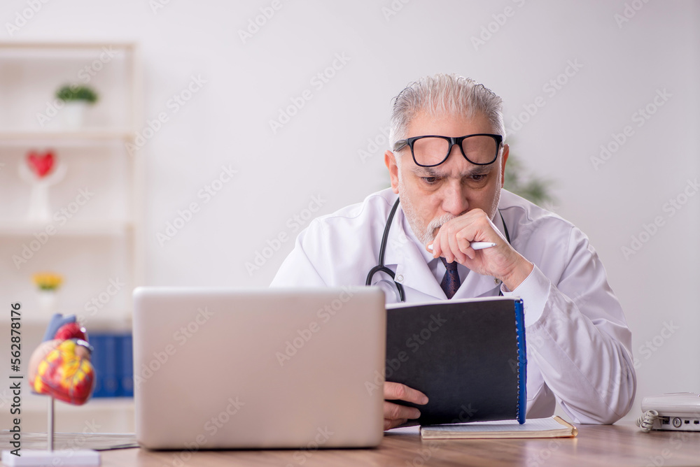Old male doctor working in the clinic Old male doctor working in the clinic