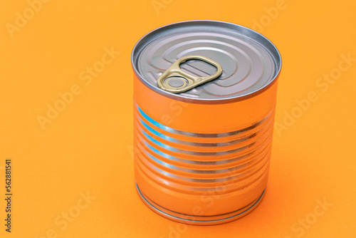 Unopened Tin Can with Blank Edge on Orange Background. Canned Food. Aluminum Can for Safe and Long Term Storage of Food. Steel Sealed Food Storage Container