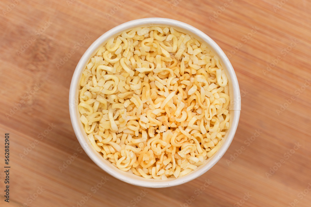 Instant Noodles in Disposable Cup on Wooden Background - Top View. Asian Fast Food. Quick Lunch Instant Noodles in Disposable Cup on Wooden Background - Top View. Asian Fast Food. Quick Lunch