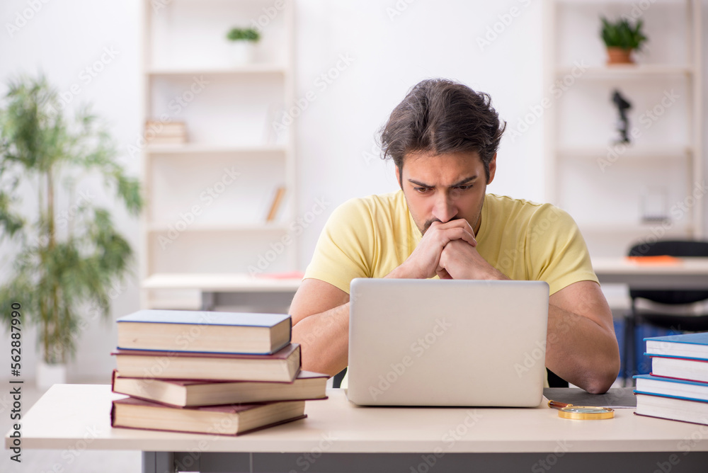 Young male student in telestudying concept Young male student in telestudying concept