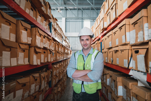 Portrait of a worker in the warehouse look at the camera and check the stock is on the shelves at the manufacturing.