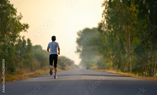 A man jogging alone through the road in morning.