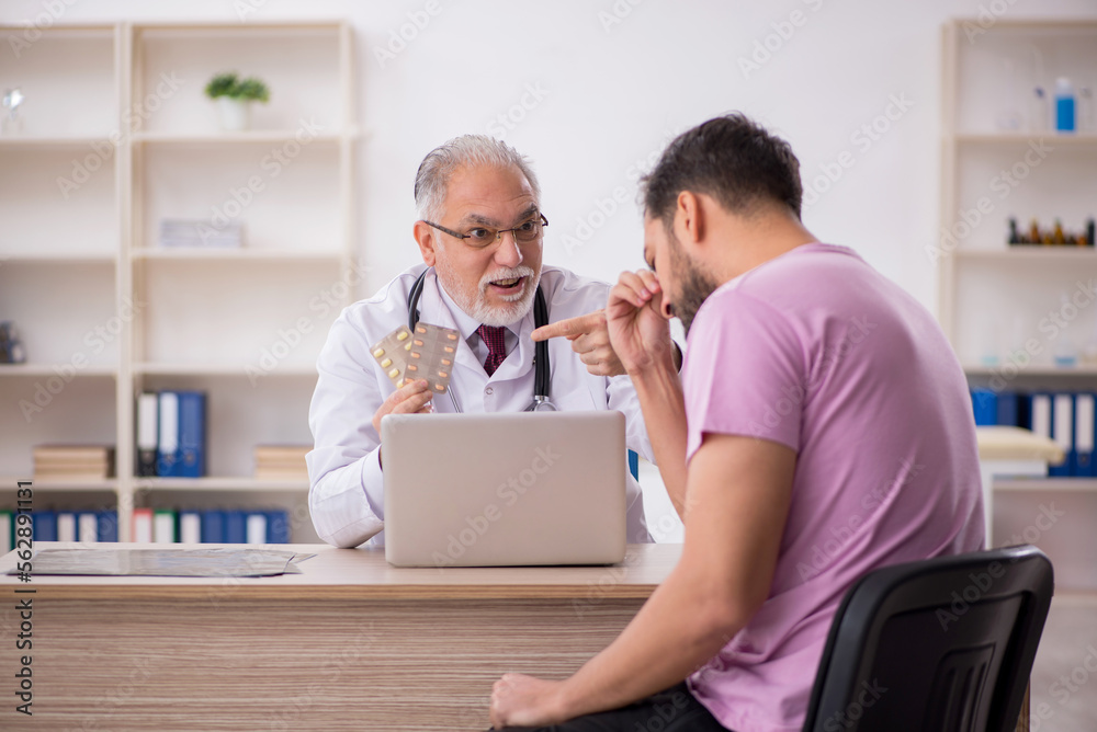 Obraz premium Young male patient visiting old male doctor