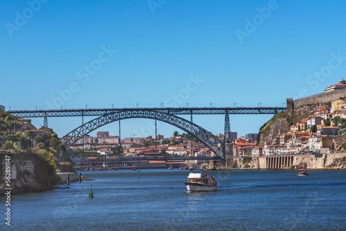 Small boats on the Douro River in Porto with the Luis I Bridge in the background © Terri