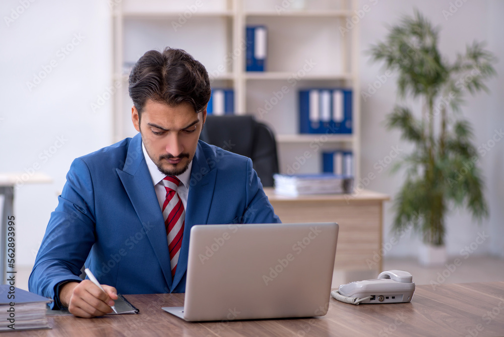 Young male employee working in the office Young male employee working in the office