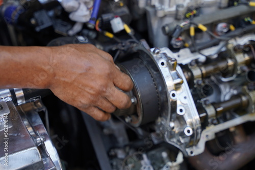 Hands working on car's engine in a garage