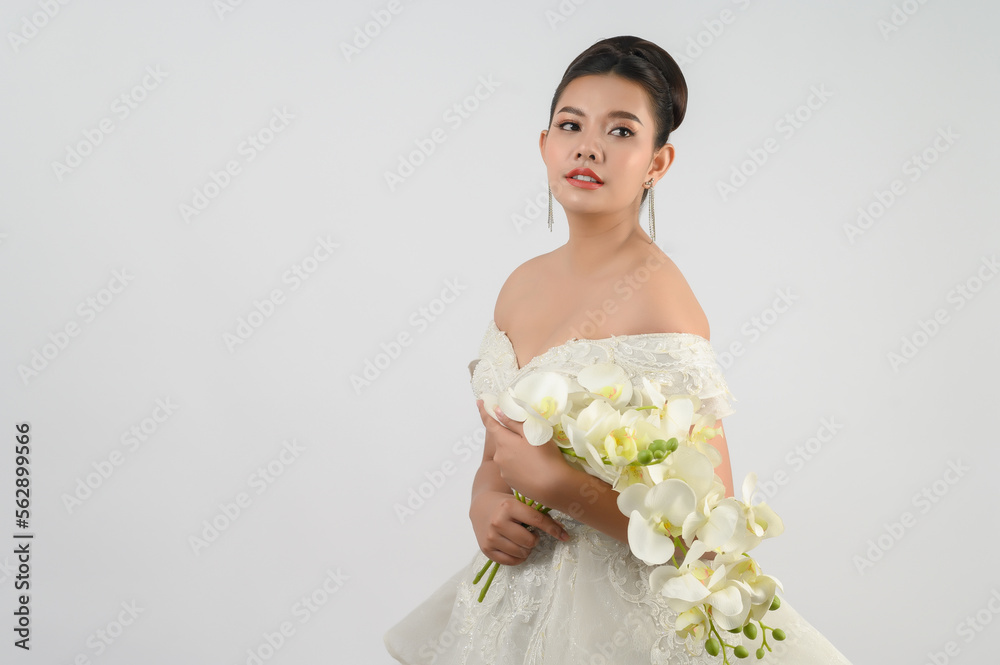 Young asian beautiful bride with orchid bouquet on white background Young asian beautiful bride with orchid bouquet on white background