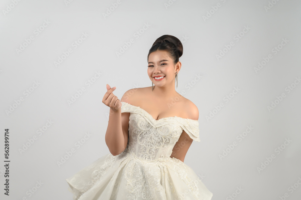 Young asian beautiful bride pose love with finger on white background Young asian beautiful bride pose love with finger on white background