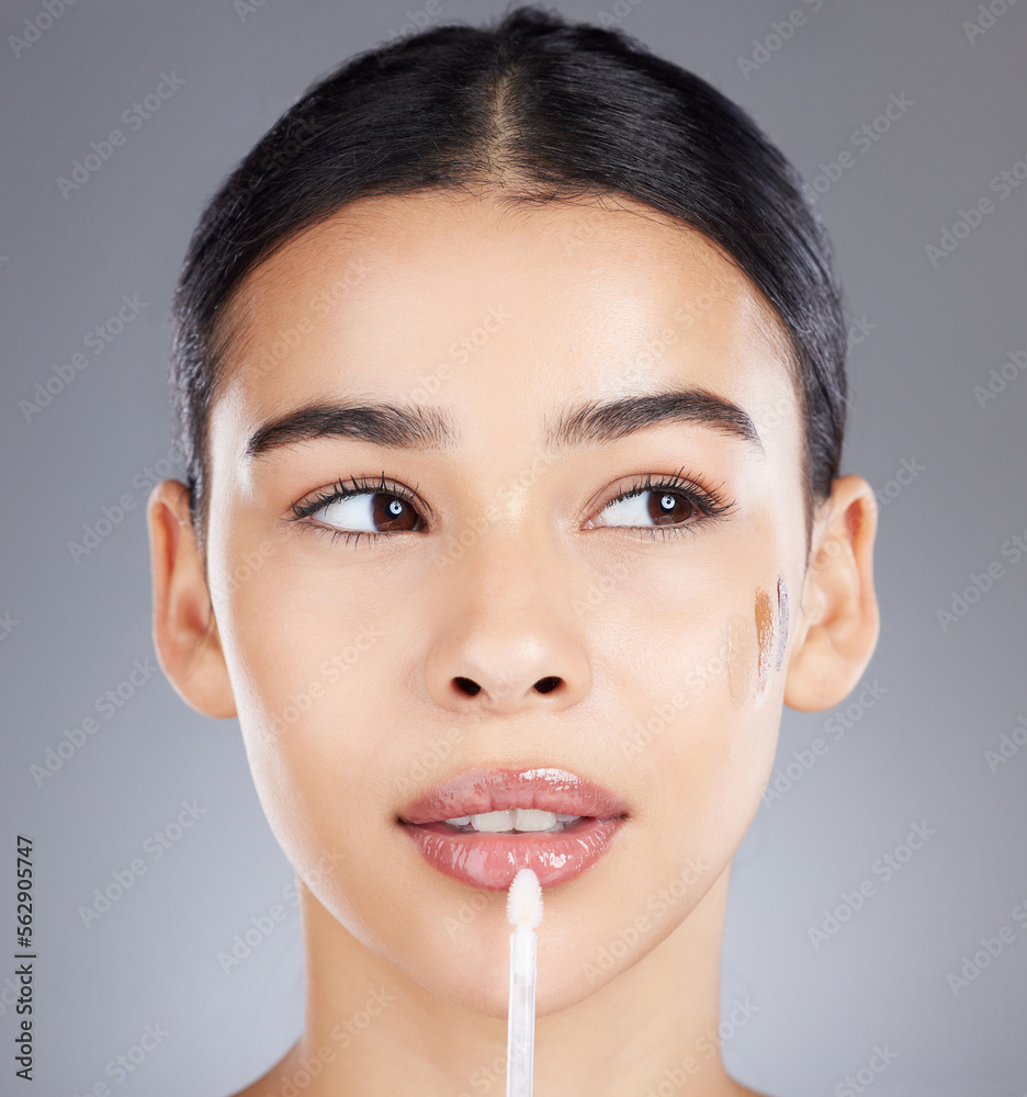 Woman, lip gloss and face makeup isolated on a grey background for beauty, glow or cosmetics. Beautiful female model applying glowing or glossy lipstick to lips, mouth or skin for cosmetic facial Woman, lip gloss and face makeup isolated on a grey background for beauty, glow or cosmetics. Beautiful female model applying glowing or glossy lipstick to lips, mouth or skin for cosmetic facial
