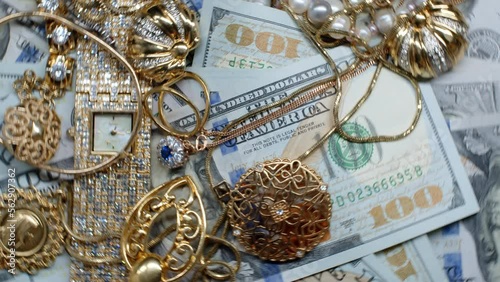 4k rotating footage of many one hundred dollar bills and gold jewelry.US currency, precious metals and stones. Profit. The attachment. Accumulated values. Vintage and antique expensive rare things