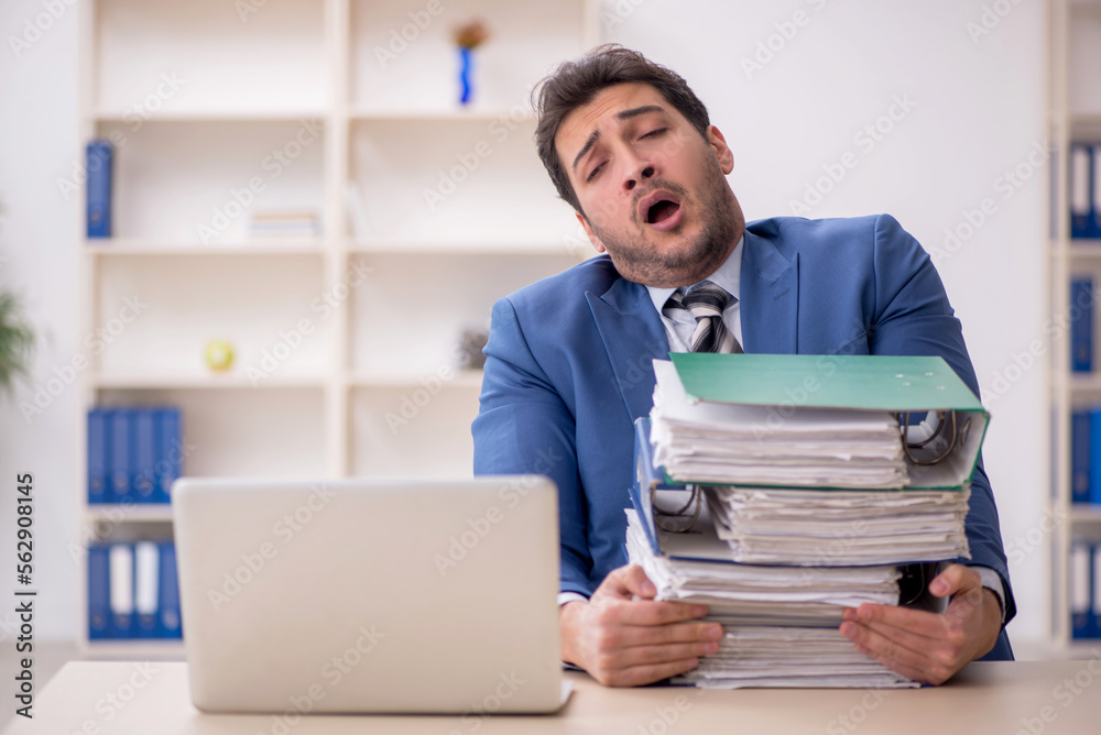 Young male employee and too much work in the office