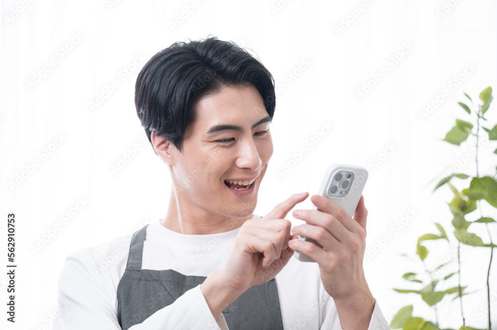 The image of an Asian male who can find something on his phone and request service. The image of an Asian male who can find something on his phone and request service.