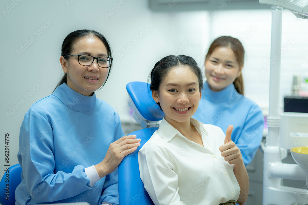Portrait of girl patient smile, sitting on dental chair after doctor and assistant provide medical service. Young woman feel happy for oral care treatment services from professional dentist. Portrait of girl patient smile, sitting on dental chair after doctor and assistant provide medical service. Young woman feel happy for oral care treatment services from professional dentist.