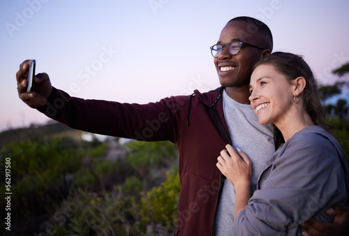 Interracial couple, phone and smile for selfie, travel or adventure trip together in the nature outdoors. Happy man holding smartphone and taking a photo with woman smiling in happiness for journey