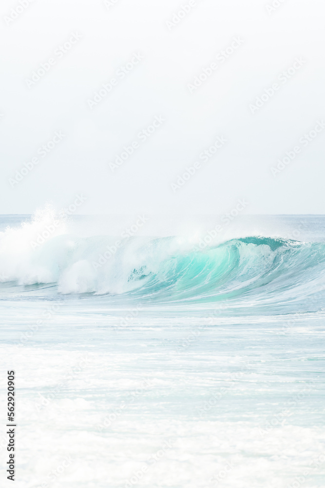 (Selective focus) Stunning view of some ocean waves breaking on the shore during a beautiful sunny day. Crushing waves, ocean waves relaxation. Bali, Indonesia.