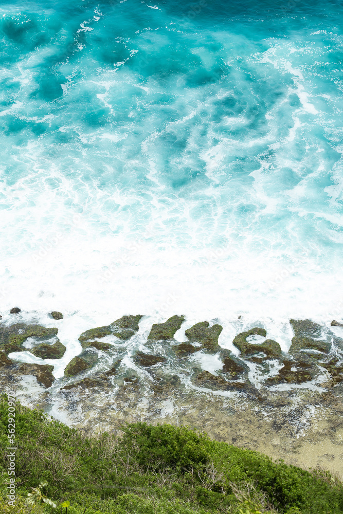 (Selective focus) Stunning view of some ocean waves breaking on the shore during a beautiful sunny day. Crushing waves, ocean waves relaxation. Bali, Indonesia.