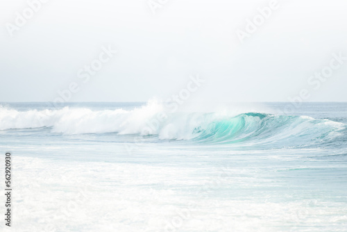(Selective focus) Stunning view of some ocean waves breaking on the shore during a beautiful sunny day. Crushing waves, ocean waves relaxation. Bali, Indonesia.