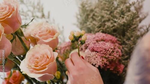 Placing hypericum in a Pink Rose Bouquet before Valentine's Day. photo