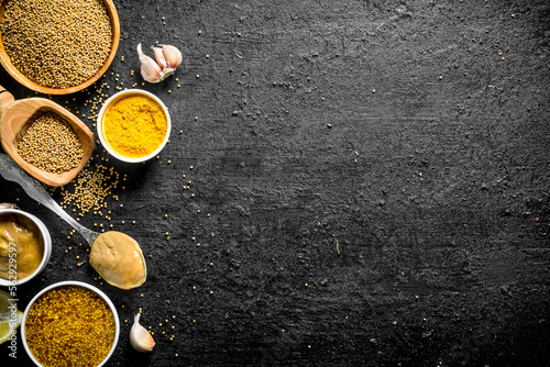 Different types of mustard with garlic cloves.