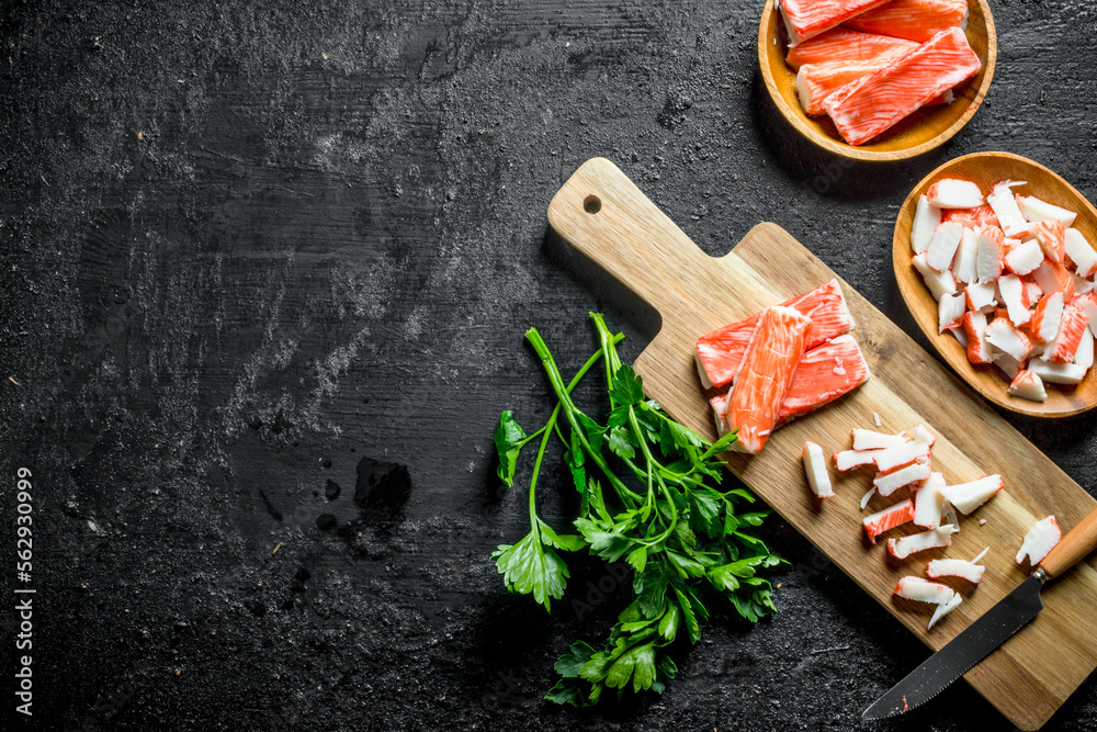 Chopped crab sticks with a knife and parsley. Chopped crab sticks with a knife and parsley.