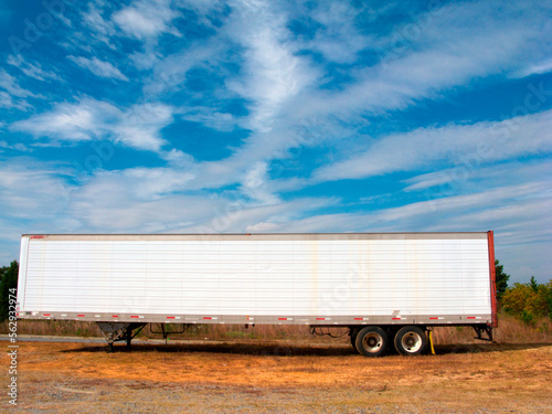 Old Trailer with white clouds and blue sky in background.