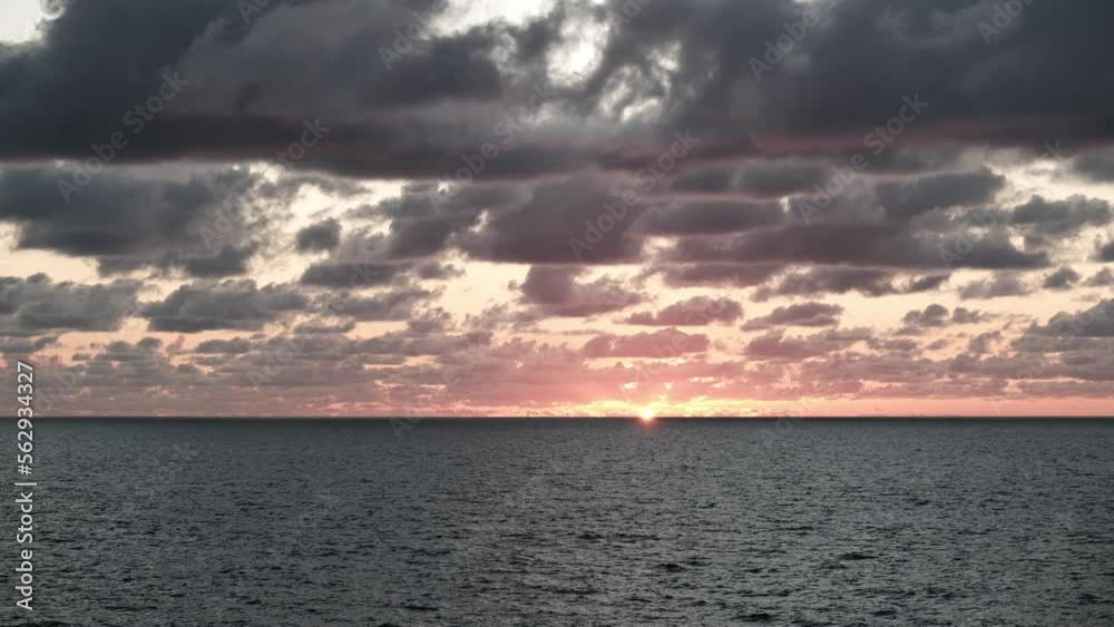 Stunning view of sunset behind the horizon of sea, scenic view of clouds and waves at dusk, time lapse Stunning view of sunset behind the horizon of sea, scenic view of clouds and waves at dusk, time lapse
