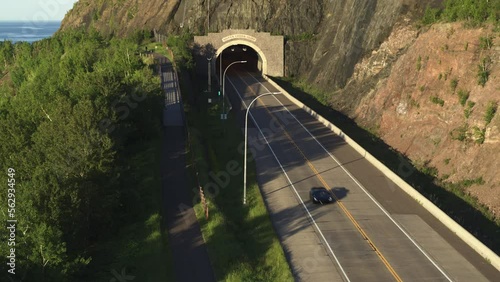 Aerial, luxury super car driving out of tunnel on a paved road in the United States photo