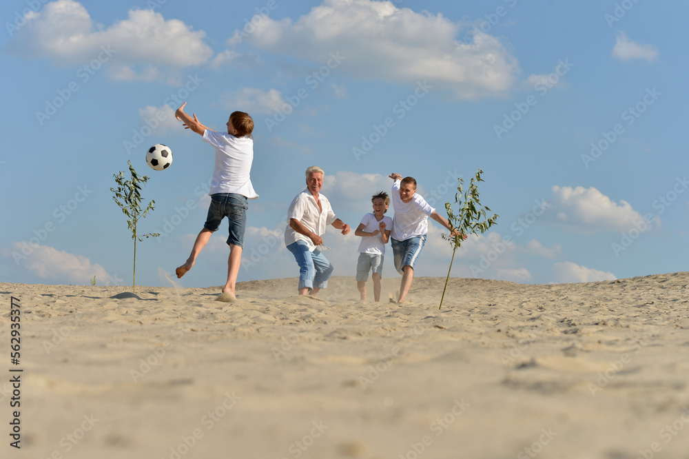 Family playing football on a beach in summer day Family playing football on a beach in summer day