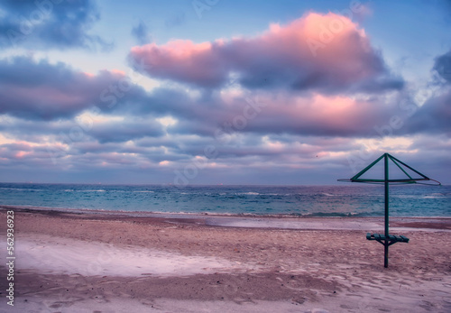 Seascape. Sandy deserted beach in the off season and pink clouds at sunset.  © Ann Stryzhekin