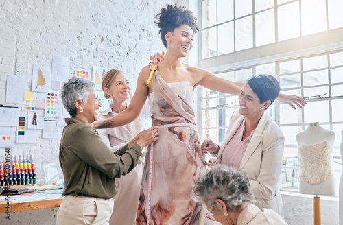 Model, designer women and dress fitting with help, design or teamwork for runway vision in workshop. Happy creative team, woman collaboration and fashion fabric with diversity, goals or helping hand