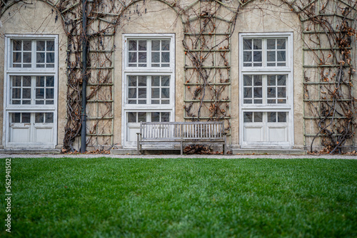 wooden chairs on lush green lawn withancient wall