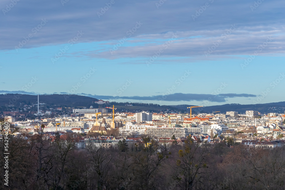 Austrian city of Vienna, panorama from a height, city buildings and mountains, blue sky.