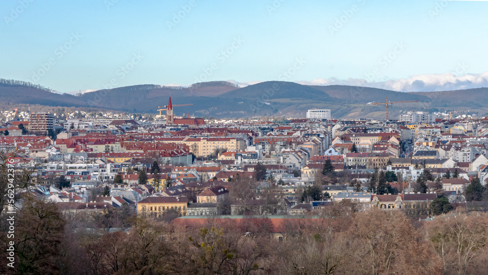 Austrian city of Vienna, panorama from a height, city buildings and mountains, blue sky.
