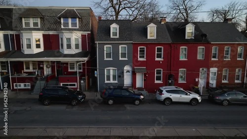 Aerial truck shot of colorful row houses during blue hour in American city. Dark, night urban home establishing shot. photo