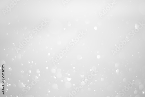 White glitter vintage lights background. White bokeh shiny on dark background.