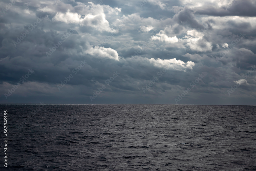 Fototapeta premium Sea with dramatic rainy clouds and sun beams.