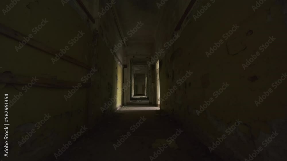 Creepy person walking at end of decaying building corridor Creepy person walking at end of decaying building corridor