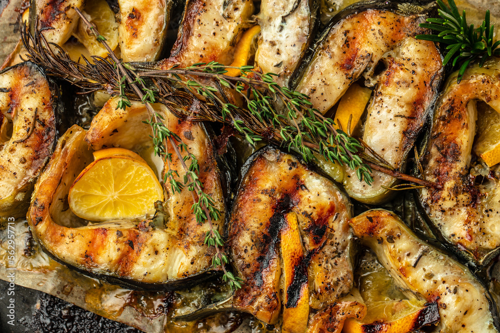 Sturgeon steaks on the grill with lemon herbs and spices. Food recipe background. Close up