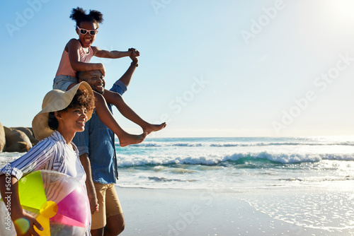 Walking, beach and profile of relax black family travel, happy and enjoy outdoor quality time together. Ocean sea water, blue sky mockup or freedom for bonding people on Jamaica holiday in summer #562958918