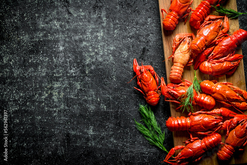 Boiled crayfish on a wooden cutting Board with dill.