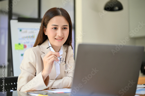 Wallpaper Mural Professional Asian businesswoman analyzing financial data, focusing on her tasks on laptop Torontodigital.ca
