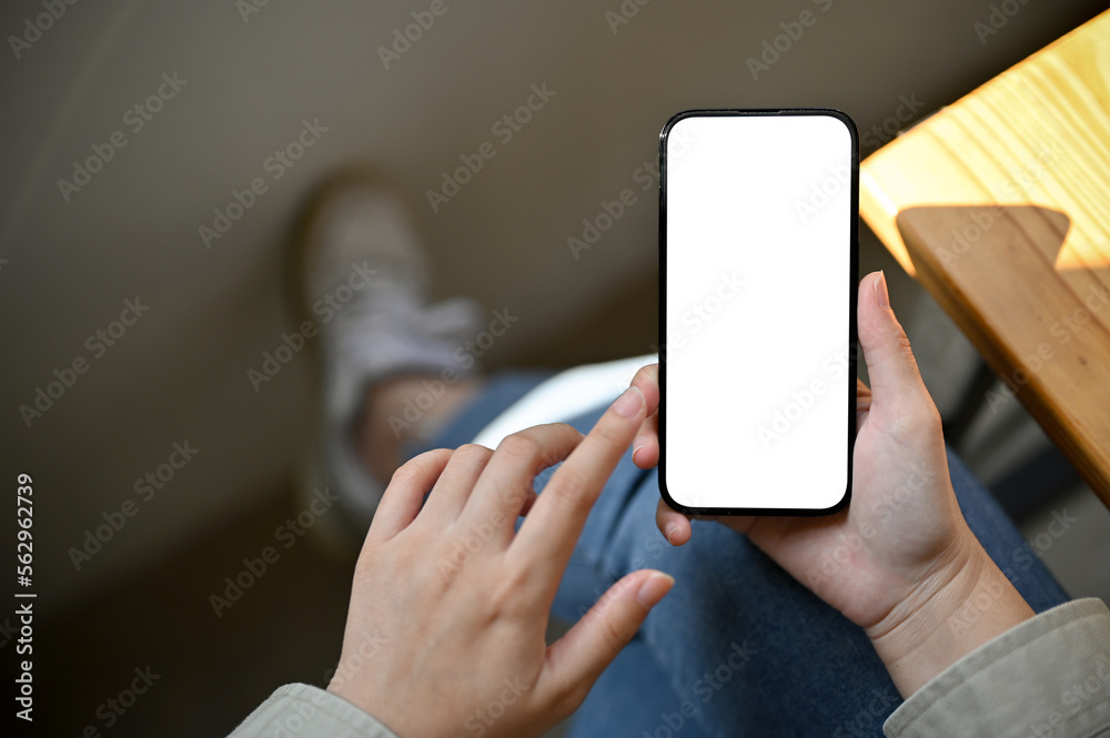 A female using her phone while relaxing in the coffee shop, close-up smartphone mockup. top view - obrazy, fototapety, plakaty 