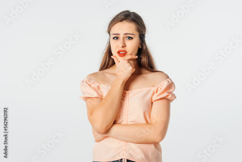 Hmm interesting. Curious brunette girl planning perfect plan, rub chin, squinting suspicious and thoughtful peek at camera, thinking, pondering between nice choice
