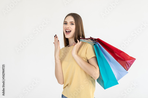 Shocked young pretty woman with shopping bags on white background