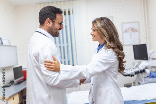 Two Professional confident doctor shaking hands while standing at the clinic .Teamwork of caucasian medical meeting and greeting by handshake at hospital .Medical team, health care concept.
