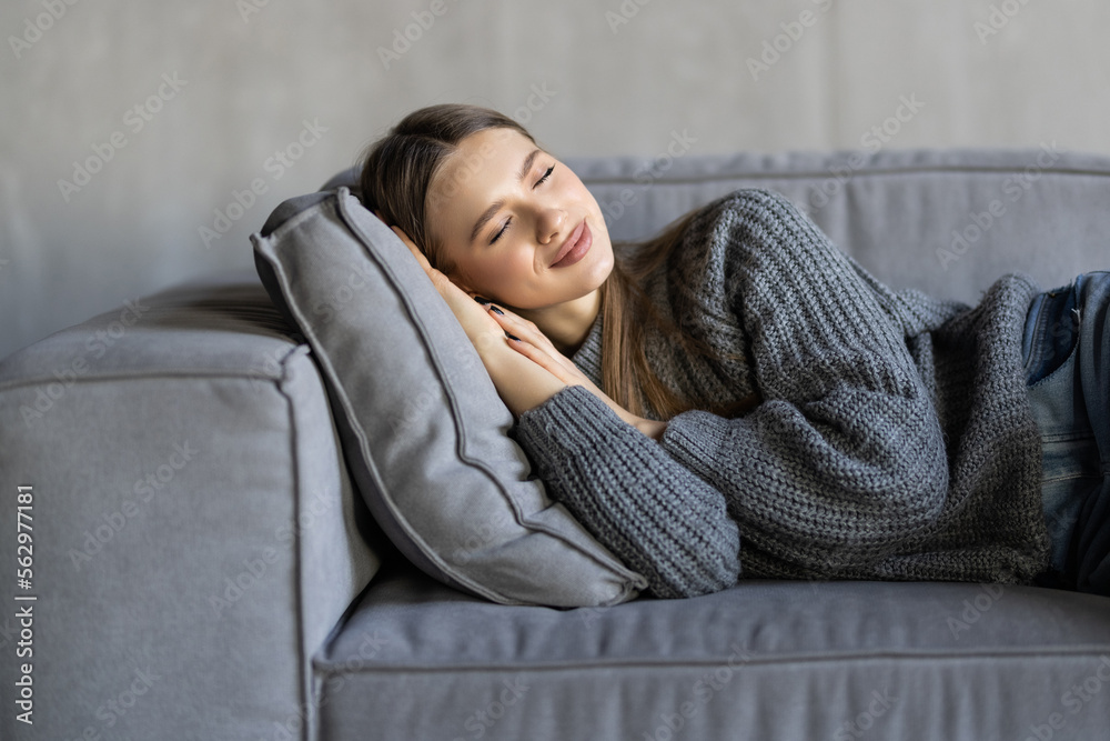 Exhausted young woman lying on comfortable sofa in living room sleeping after hard-working day, tired millennial female fall asleep on couch at home, take nap or daydream, fatigue concept Exhausted young woman lying on comfortable sofa in living room sleeping after hard-working day, tired millennial female fall asleep on couch at home, take nap or daydream, fatigue concept