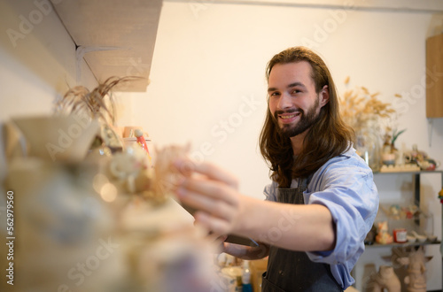 Businessman having a little ceramic business  Checking products in the store to prepare them for sale or to order more production.