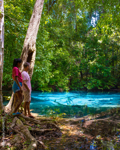 A couple visits the Emerald pool and Blue pool in Krabi Thailand, Emerald pool and Blue pool, trees, and mangroves with crystal clear water Krabi Province, Thailand.  photo