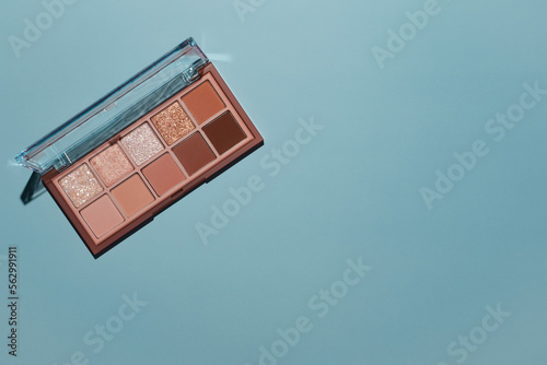 Fotobehang Top view eyeshadow rose gold glitter and beige mauve and brown matte palette on blue background