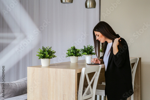 Happy young european saleswoman looking at the camera while greeting a customer. Smiling female executive manager, secretary offering professional business services with digital tablet standing in the